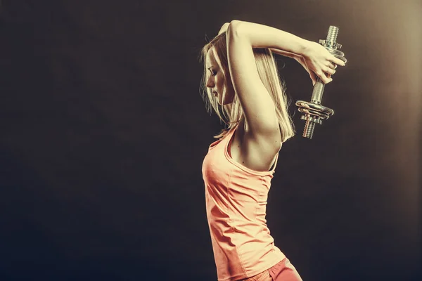 Fit woman exercising with dumbbells.