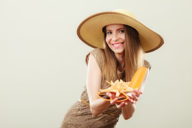Kadın güneş gözlüğü ve güneş koruyucu losyon tutar