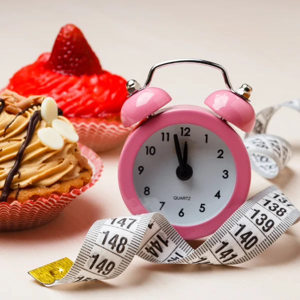 Cinta métrica de alimentos dulces y reloj en la mesa —  Fotos de Stock
