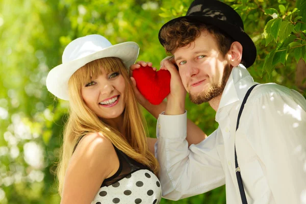 Retro style couple in love with red heart Stock Picture