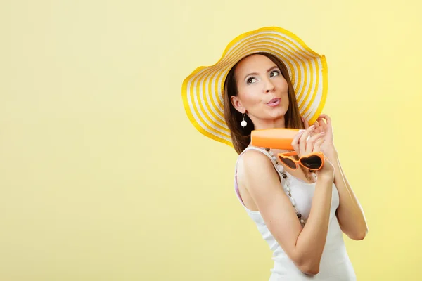 Mujer en sombrero de verano sostiene gafas de sol loción protector solar —  Fotos de Stock