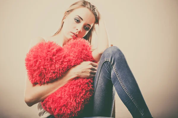 Sedih bahagia wanita memegang bantal jantung merah — Stok Foto
