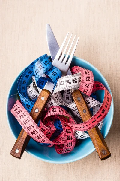 Muitas fitas de medição coloridas na tigela na mesa — Fotografia de Stock