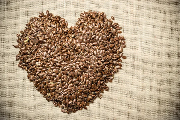 Surowe nasiona lnu, w kształcie serca — Zdjęcie stockowe