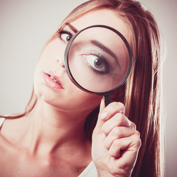 Girl holding on eye magnifying glass
