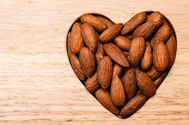 Badem ahşap yüzey zemin üzerinde kalp şeklinde