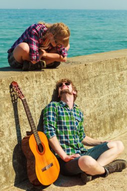Genç adam onun kız arkadaşı deniz kenarında gitar çalmak