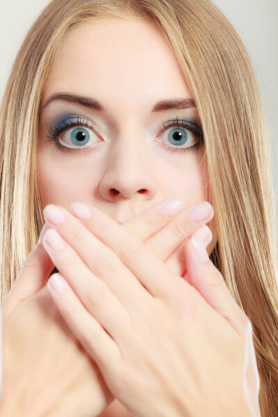 Amazed woman covering her mouth with hands