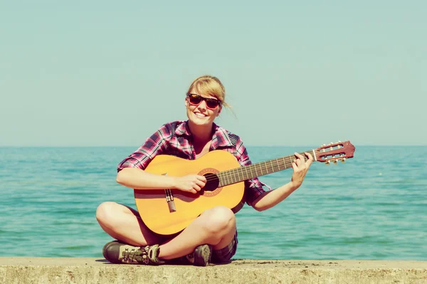 Jonge vrouw met gitaar buiten — Stockfoto