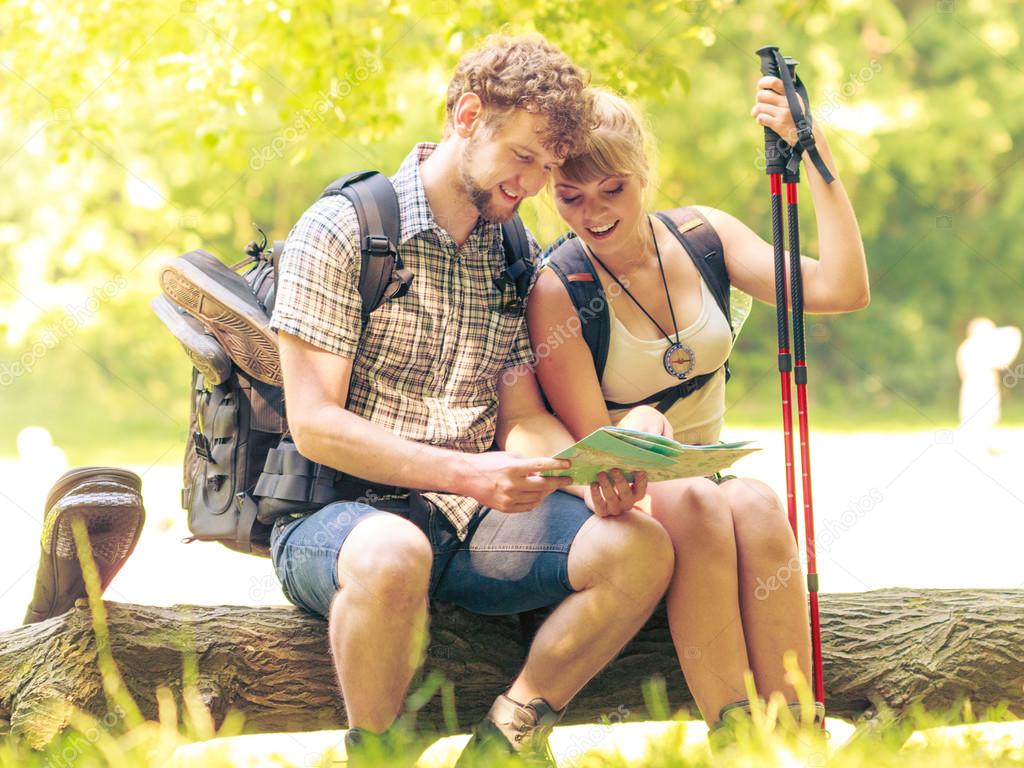 Backpackers couple reading map