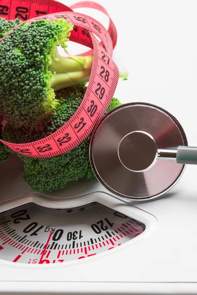 Broccoli med stetoskop på vita skalor — Stockfoto