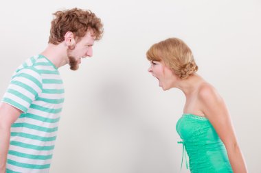 Öfkeli kadın ve erkek birbirlerine bağırıyorlar.