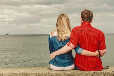 Deniz kıyısında çift oturma sarıldı