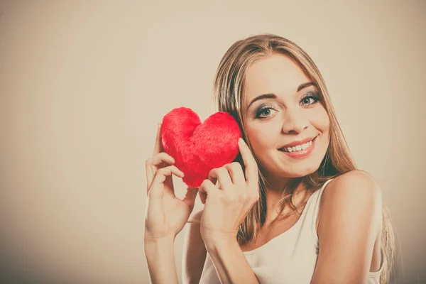 Mujer sonriente sosteniendo el corazón rojo — Foto de Stock