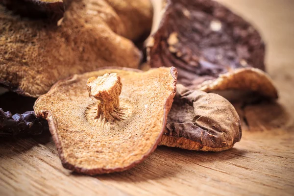 Trockene Pilze auf rustikalem Holztisch. — Stockfoto