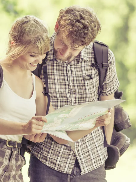 Turistas con mochileros leyendo mapa —  Fotos de Stock