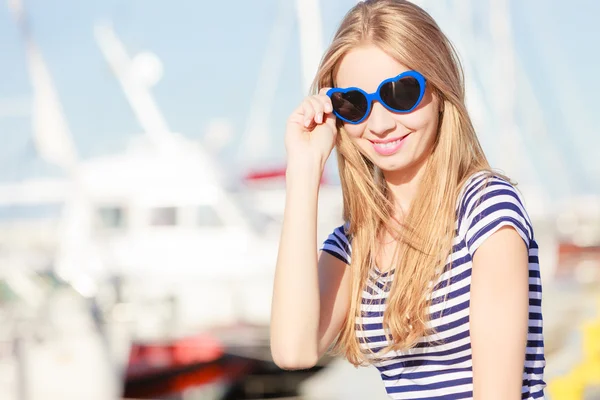 Blond kvinna mot båtar i hamn — Stockfoto