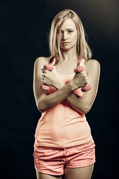 Фитнес-девушка с гантели поигрывая мышцы в тренажерном зале — стоковое фото