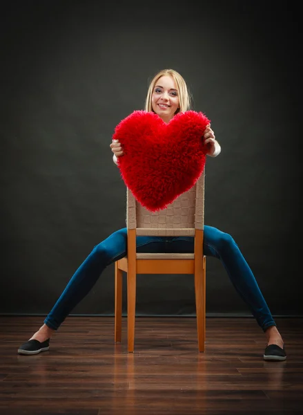 Mujer joven sosteniendo almohada del corazón — Foto de Stock