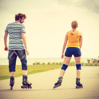Tekerlekli paten üzerinde genç Çift