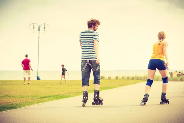 Pareja joven en forma en patines — Foto de Stock