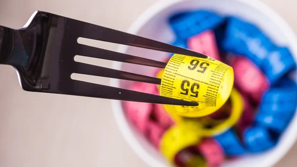 Many colorful measuring tapes in bowl on table — Stock Photo, Image