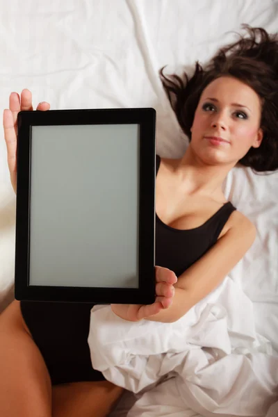 Sexy lazy girl lying with tablet touchpad on bed — Stock Photo, Image