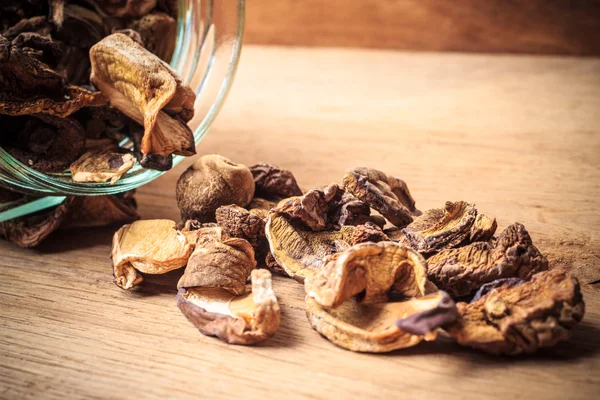 Droge paddestoelen in pot op houten tafel. — Stockfoto