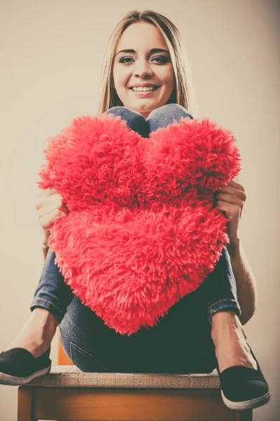 Mujer sosteniendo corazón en forma de almohada símbolo de amor — Foto de Stock