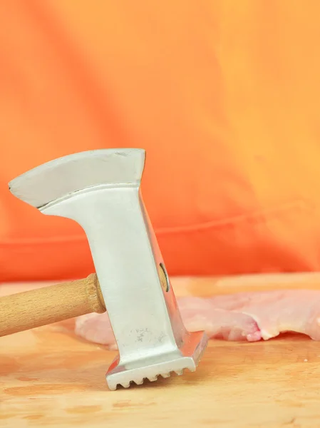 Pechuga de pollo con ablandador de carne sobre tabla de madera — Foto de Stock