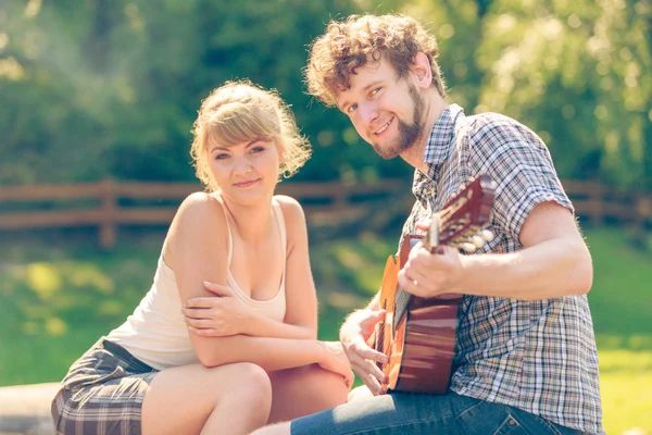 Jovem casal camping tocando guitarra ao ar livre — Fotografia de Stock