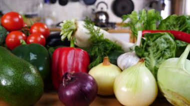 Mutfak masasında yavaş çekimde yakalanan çeşitli sağlıklı sebzeleri kapatın. Doğal beslenme konsepti..
