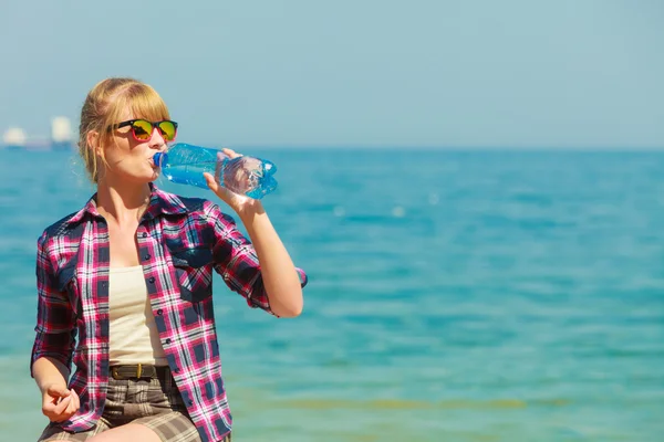 Jonge vrouw drinken van water buiten — Stockfoto