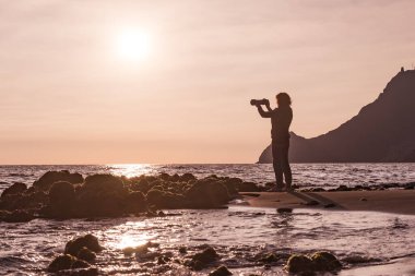 Kameralı kadın turist Monsul sahilinde fotoğraf çekiyor. Cabo de Gata Nijar Doğal Parkı, Almerya, Endülüs, İspanya.