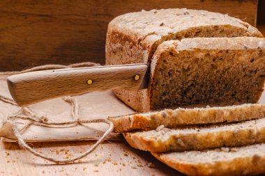 Kepekli ekmek kesme tahtası üzerinde dilimlenmiş