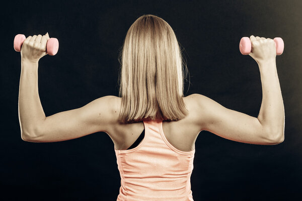 Fitness sporty girl lifting weights back view