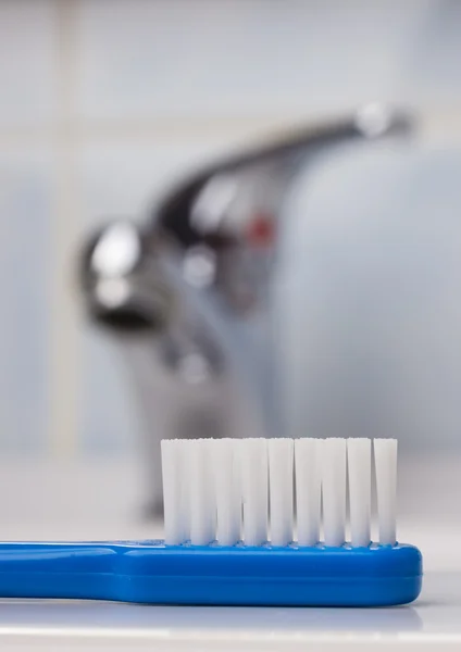 Escova de dentes azul no banheiro na pia — Fotografia de Stock