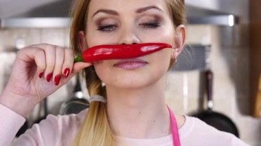 Kırmızı kırmızı biber bıyıkmış gibi davranarak eğlenen komik kadın. Sağlıklı gıda ve diyet konsepti.