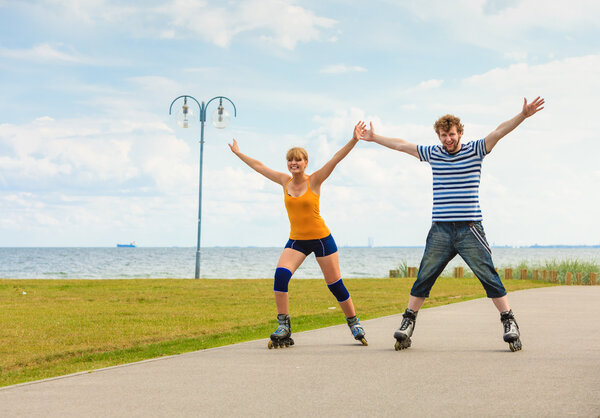 Young couple on roller skates riding outdoors