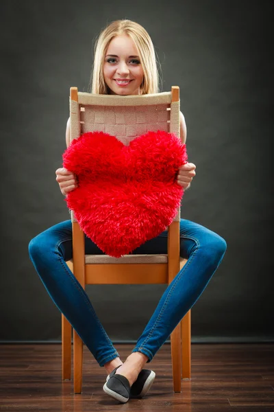 Mujer sosteniendo corazón en forma de almohada símbolo de amor — Foto de Stock