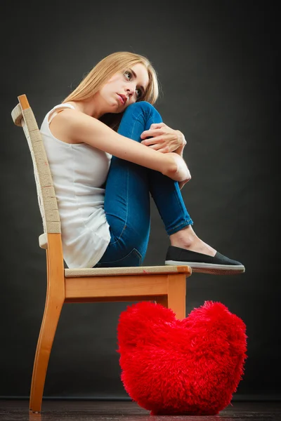 Mulher infeliz triste com travesseiro coração vermelho — Fotografia de Stock