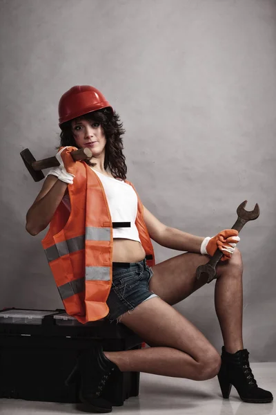Sexy girl holding wrench spanner and hammer — Stock Photo, Image