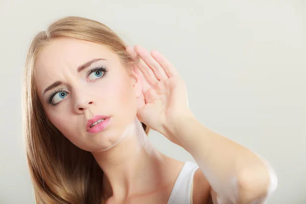 Mujer con la mano detrás de la oreja espiando — Foto de Stock