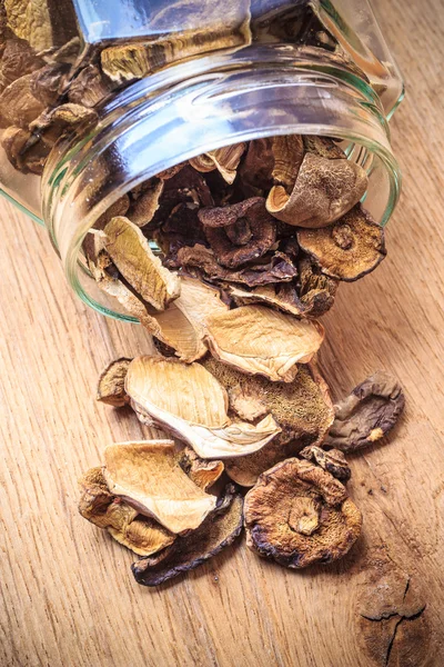 Droge paddestoelen in pot op houten tafel. — Stockfoto