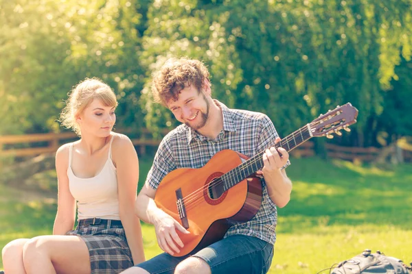 Молода пара кемпінгу грає на гітарі на відкритому повітрі — стокове фото