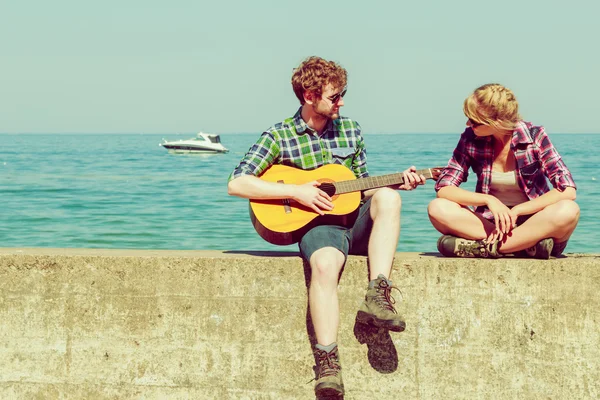 Giovane uomo che suona la chitarra per la sua ragazza all'aperto — Foto Stock
