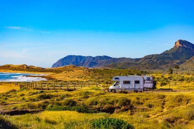 Sahilde kamp yapan karavanlı deniz manzaralı bir karavan. İspanya Murcia bölgesi, Calblanque Bölgesel Parkı.
