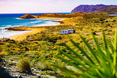 Sahilde kamp yapan karavanlı deniz manzaralı bir karavan. İspanya Murcia bölgesi, Calblanque Bölgesel Parkı.