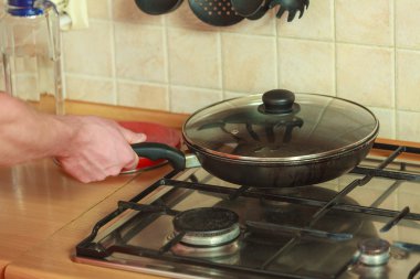 Fry pan kızartma ile insan eli closeup.