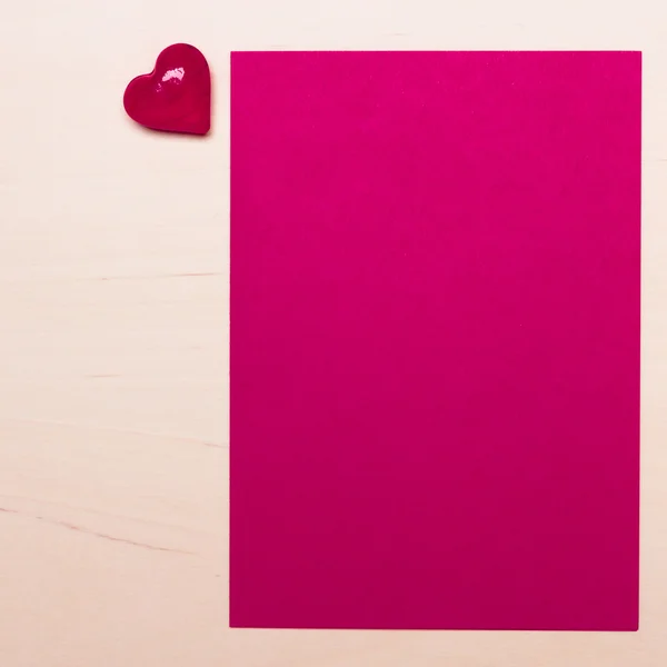 Hoja en blanco de papel y corazón en la mesa —  Fotos de Stock